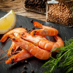 Shrimps for dinner on stone plate. Selective focus.